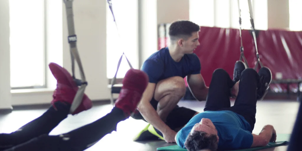 resize-15998954431986456363resize15994602981539711788videoblocksagroupofcheerfulseniorsingymwithayoungpersonaltrainerdoingexercisewithtrxr9wqctizsethumbnailfull01-1024x512